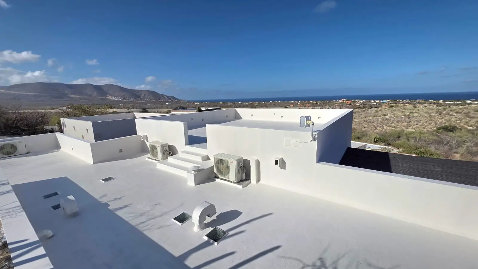 White waterproofed rooftops overlooking the sea and mountains in Baja California Sur